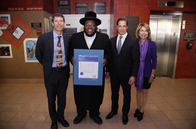 Nissim Black, songwriter, record producer and rapper, accepts a proclamation at a Miami-Dade School Board meeting.